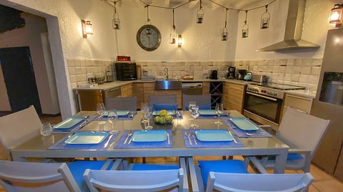 The outdoor kitchen under its lamps at night