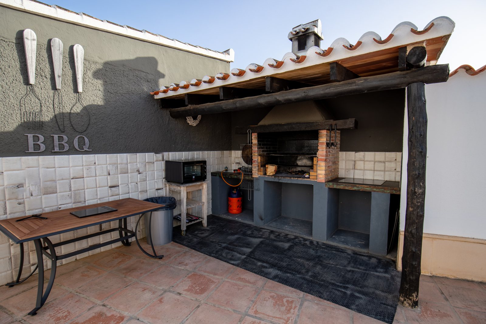 Überdachte Grillküche mit Holzkohlegrill und Arbeitsbank