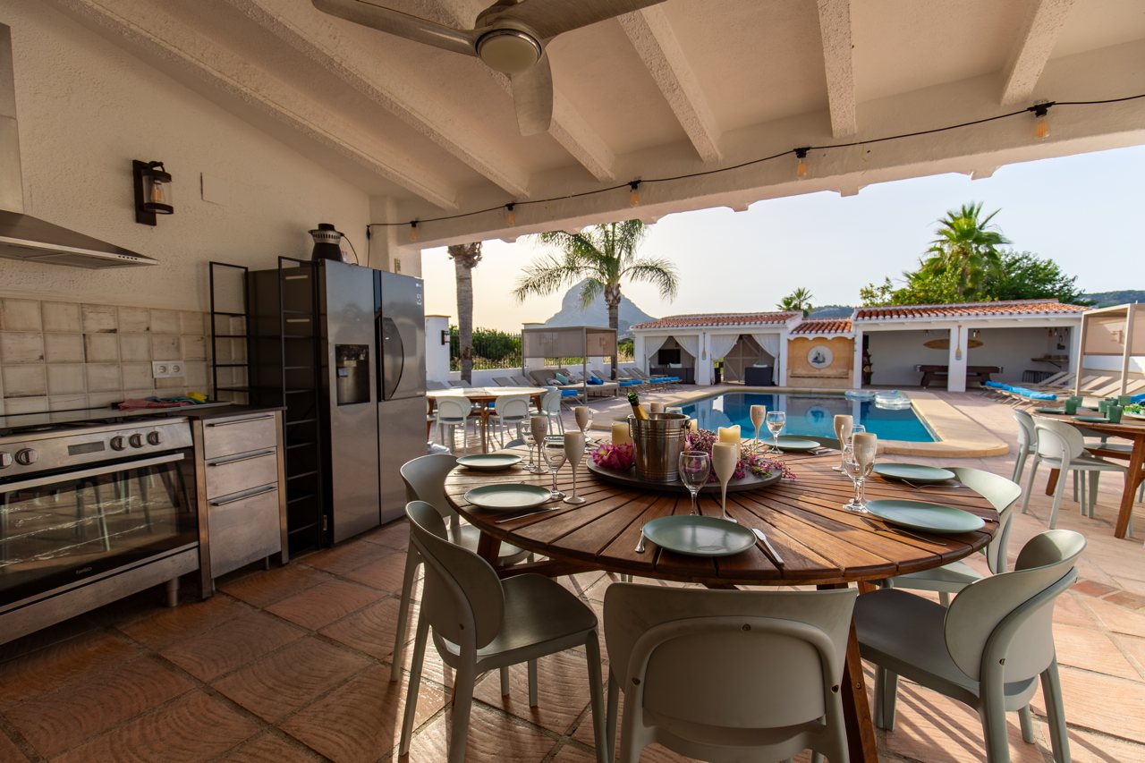 Outdoor kitchen with ovens and barbecue, pool beyond