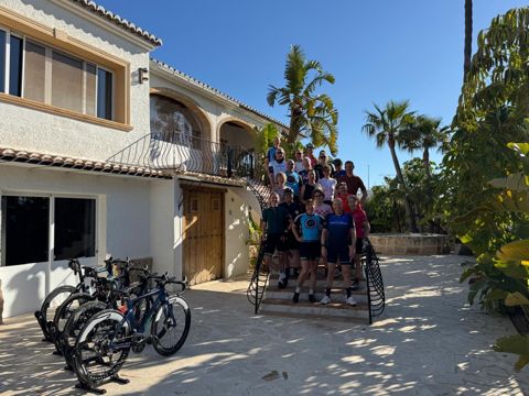 A cycling group on the steps of the villa