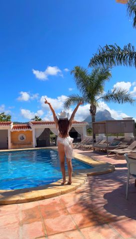 Arms up, the Montgó behind the pool