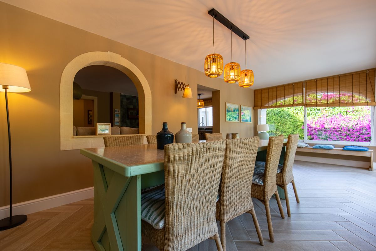 Dining corner with wicker chairs by the arched window — Nauticaa, wing one of Villa Palmview, Jávea
