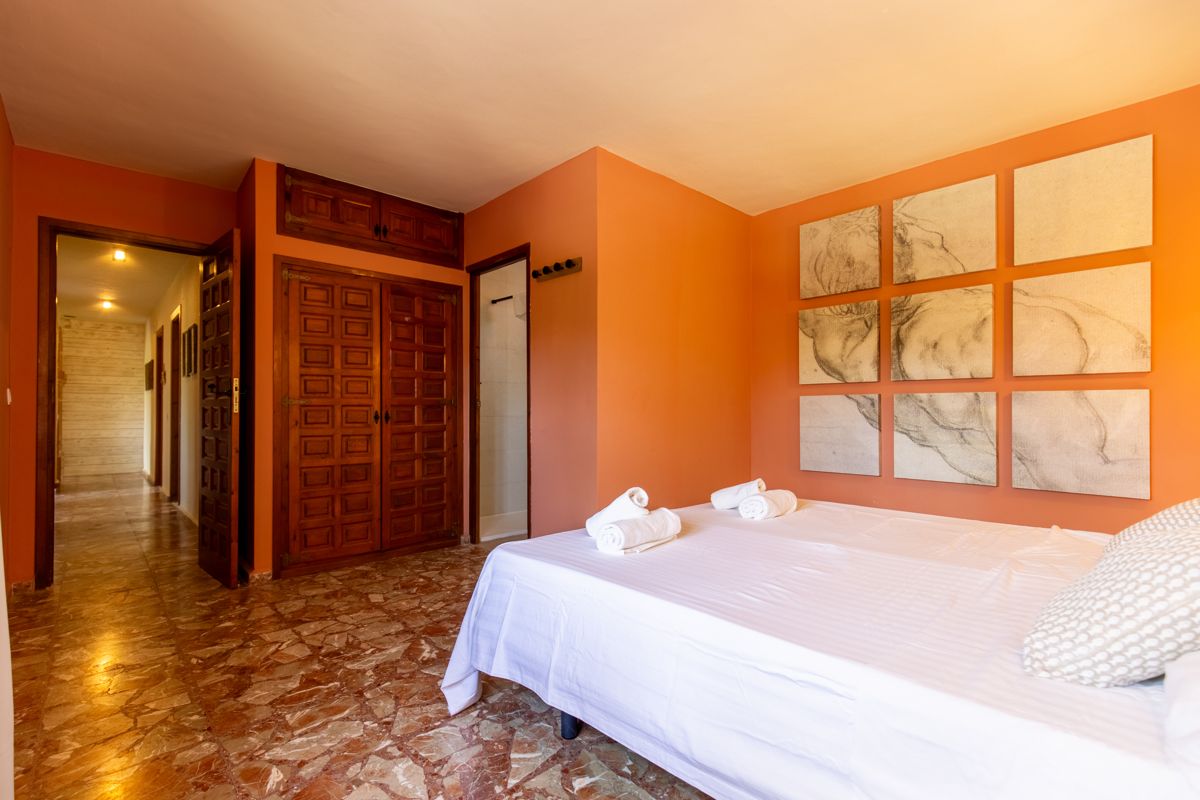 Bedroom with wooden wall and warm accent colour — Mystique Travels, wing three of Villa Palmview, Jávea