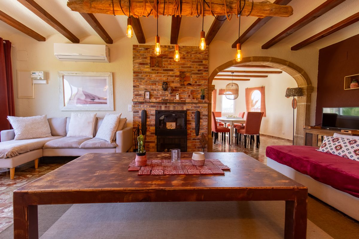 Woonkamer met houten tafel bij de haard — Mystique Travels, vleugel drie van Villa Palmview, Jávea