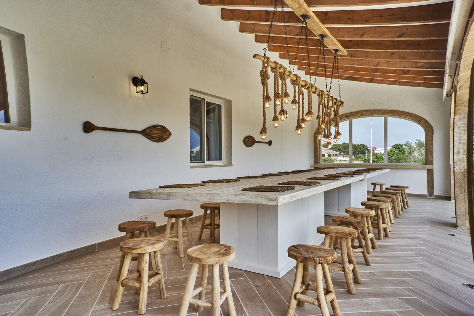 The long bar table under the beams of the covered terrace