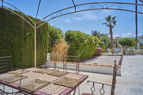 The wrought-iron pergola with its dining table