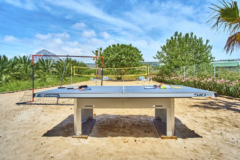 Table tennis and the volleyball net on the private beach