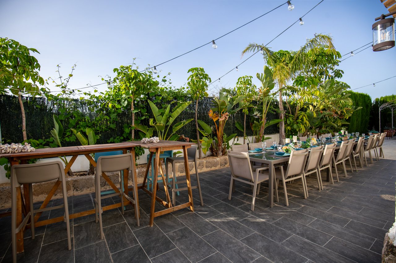 High bar table with stools under festoon lighting