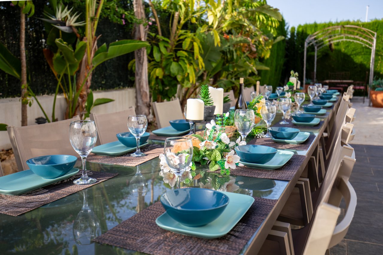 Long table laid with turquoise crockery and flowers