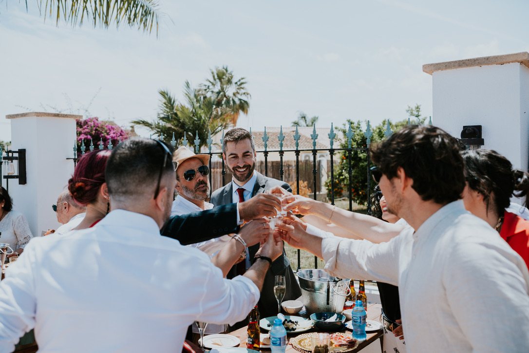 Guests raising a toast at the outdoor wedding table