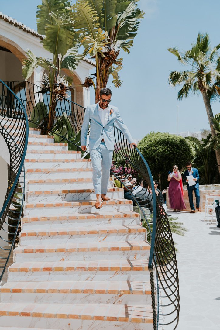 The groom coming down the villa's curved staircase