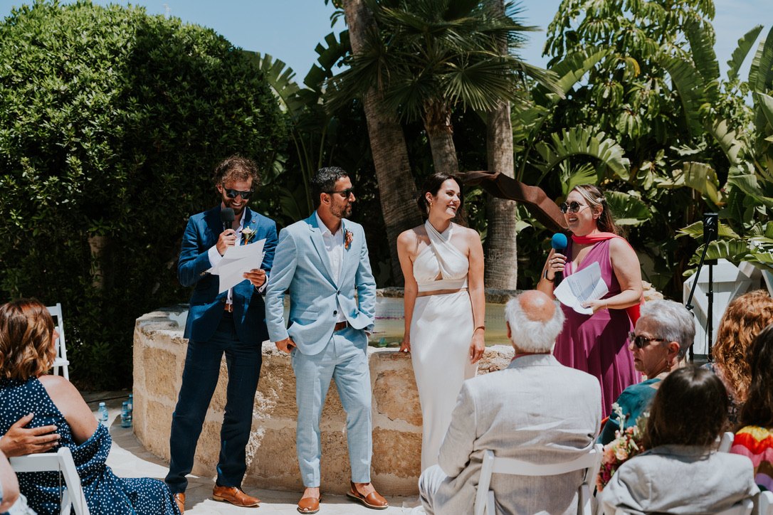 Wedding ceremony at the fountain in the garden, the couple between their celebrants