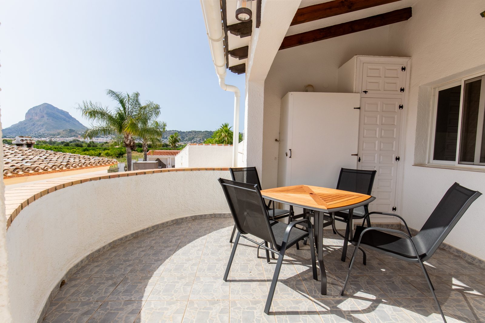 Private terrace with table and chairs facing the Montgó
