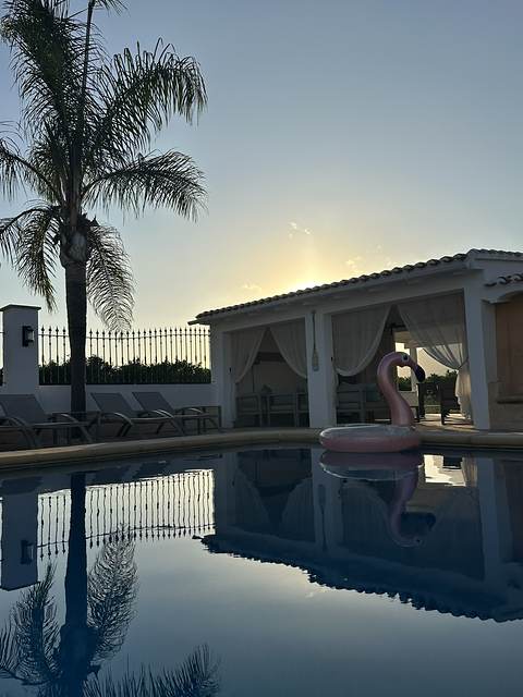 The pool at dusk, still as a mirror